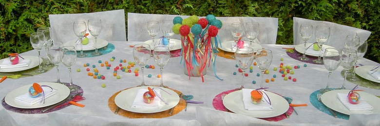 Décoration de table de baptême multicolore.